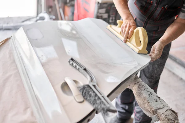 De monteur werkt met een slijpgereedschap. Schuren van auto-elementen. Garage schilderen auto service. Reparatie van het autopark na het ongeval. — Stockfoto