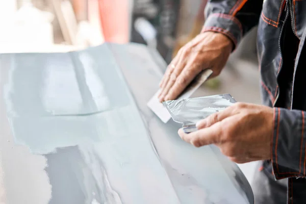 Repairing car body, Application putty close up. The mechanic repair the car. Work after the accident by working sanding primer before painting. — Stock Photo, Image