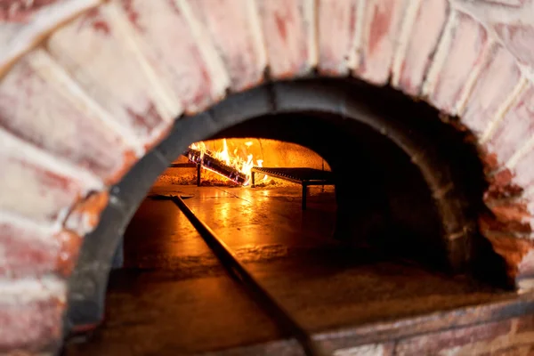 Traditional wood oven in Naples restaurant, Italy. Original neapolitan pizza. Red hot coal. Baked tasty pizza