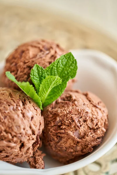 Cokelat es krim dengan daun mint. tiga bola dalam mangkuk putih di meja vintage. — Stok Foto