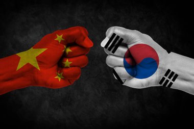 Çin, Kore 'ye karşı Güney Yüzleşmesi, Dini Çatışma. Çin ve Kore 'nin güneyinde boyanmış bayraklı erkek yumrukları. Koyu bulutlar