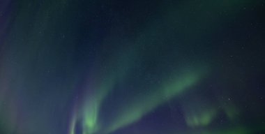 Igloo kış ormanında Aurora Borealis ile inanılmaz yıldızlı gökyüzünün arka planına karşı. Kış dağlarında kuzey ışıkları. Parlayan kutup ışıkları ve buzhane ile kış sahnesi. Noel kartpostalı