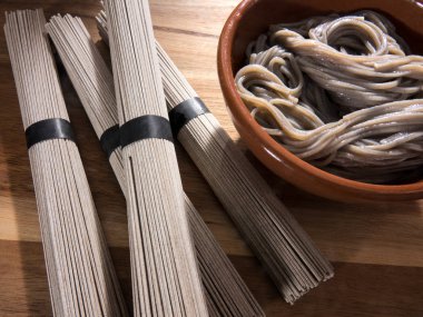 Çin buğday noodle, çiğ ve pişmiş ahşap arka plan üzerinde bir kasede