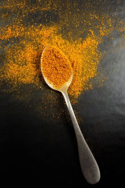 Siyah izole köri tozu ile bir kaşık üst görünümü