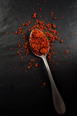 Siyah üzerine izole satay tozu ile bir kaşık üst görünümü