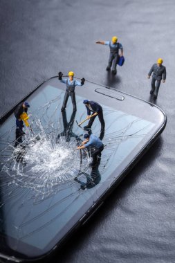 İşçiler bozuk bir cep telefonu ekranı üzerinde çalışıyorlar