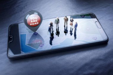 bir cep telefonu ekranında, şehir haritasıüzerinde duran bir grup insan