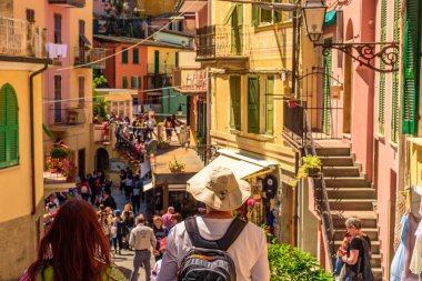 Manarola, İtalya - 29 Nisan 2017 - İki turist Liguria'daki Cinque Terre Milli Parkı'ndaki Manarola kasabasının renkli sokaklarına bakabak.