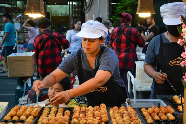Phuket, Tayland - 25 Mart 2018: Yerel satıcı kan, domuz yağı Yai, hafta sonu Pazar Phuket, Tayland, sokak boyunca top şeklindeki Japon Aperatif satmaktadır.