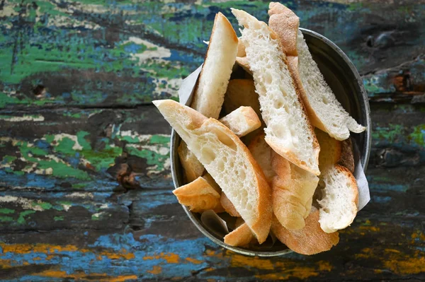 Pane tostato in un secchio su un vecchio tavolo di legno — Foto Stock