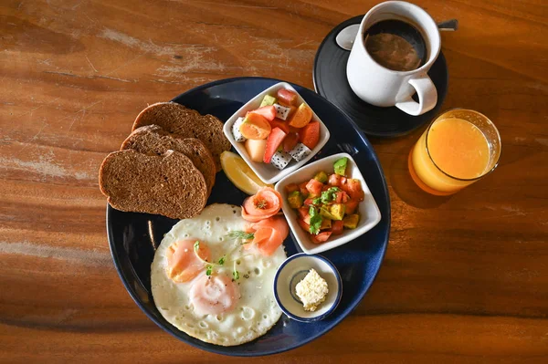 Big breakfast with eggs, fruit and bread