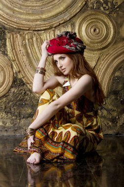 Etnik giysiler içinde altın arka plan üzerinde güzel kız