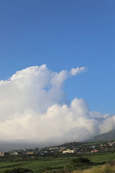 Nuvem no céu paira sobre as casas nas montanhas . — Fotografia de Stock