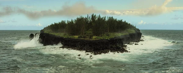 Des vagues fortes battent autour d'une petite île ronde avec des arbres . — Photo