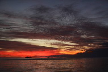 Okyanusa renkler kırmızı renkte su ve gökyüzü günbatımı