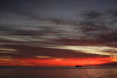 Okyanusa renkler kırmızı renkte su ve gökyüzü günbatımı