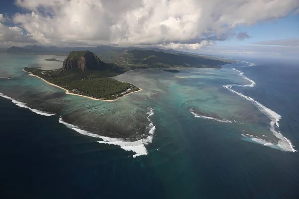 Остров омывается со всех сторон океаном и над которым собралось много облаков — стоковое фото