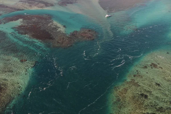 Nahaufnahme von Meerwasser in der Nähe einer Insel mit Boot — Stockfoto