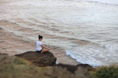 Kız taş uçurumdan oturmuş poz