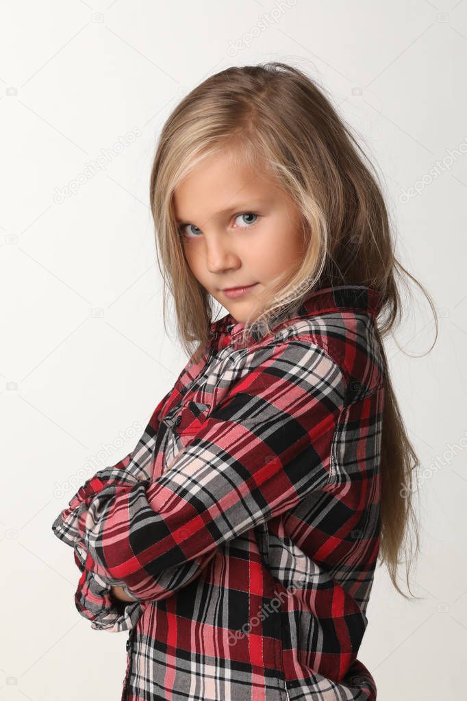 Portrait of a girl with long blond hair wearing a plaid shirt. White background