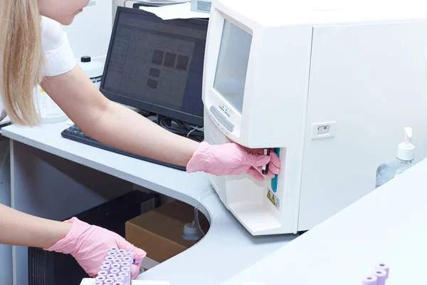 实验室的科学家在热分析仪的容器中放置有血液或尿液的试管 现代医疗计算机设备 — 图库照片