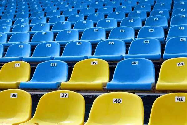 Yellow and blue plastic seats in the stadium, the concept of competition and sports.