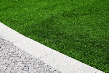 Güzel bir çim yeşil çim ve bir yol ile granit taşlar ile dekore edilmiştir..