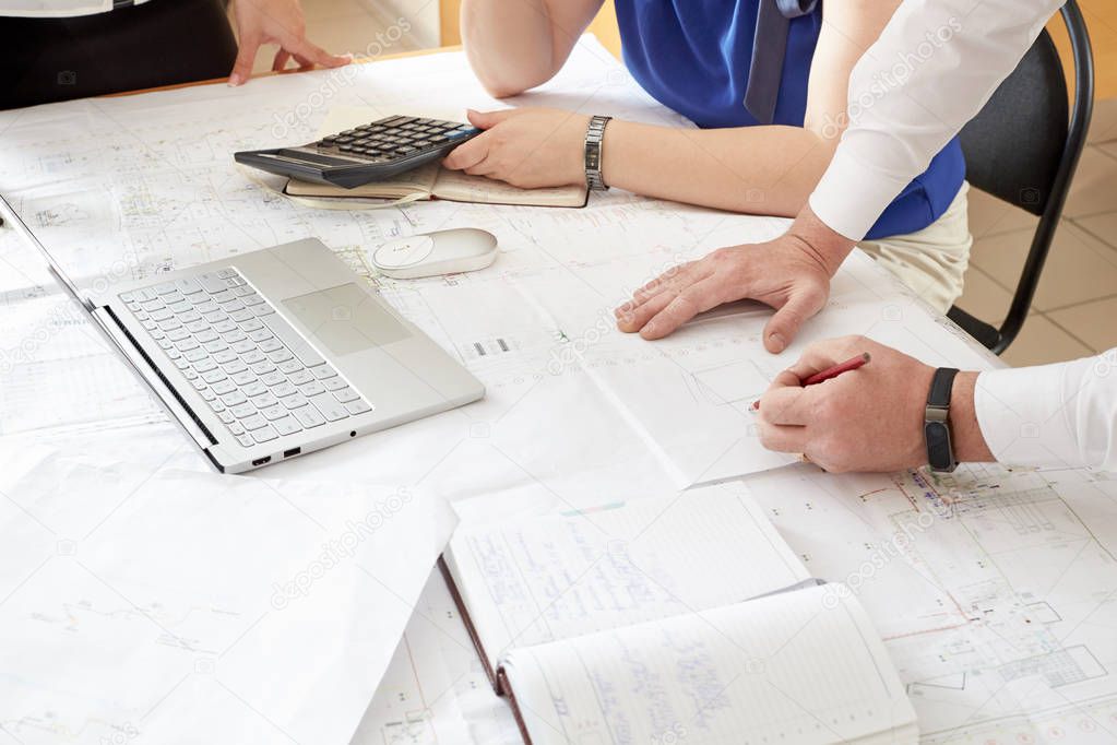 Team job. Photo young businessmans crew working with new startup project in modern loft. Generic design notebook on wood table.