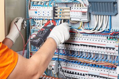 Mühendis multimetre ile güç yüksek gerilim üç faz devre kutusu sınar. Elektrik Servisi elektrik sistemi. Destek elektrikçi sigorta panelinde.
