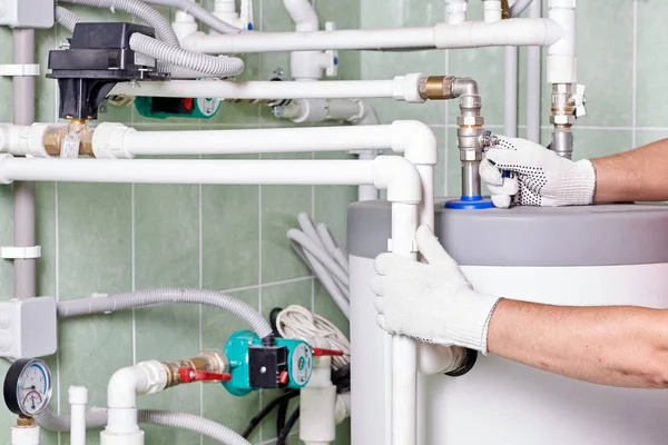 ボイラー室で加熱パイプを制御する技術者 水のメンテナンスの仕事をしていると 暖房配管 — ストック写真