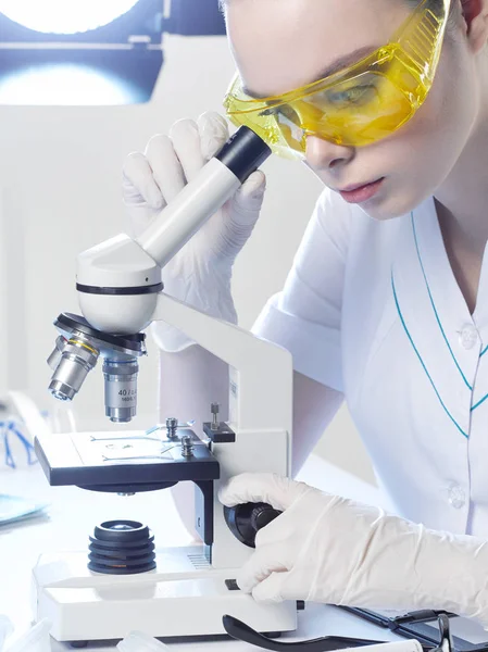 Jovem Assistente Laboratório Médico Assistente Óculos Amarelos Olha Para Microscópio — Fotografia de Stock