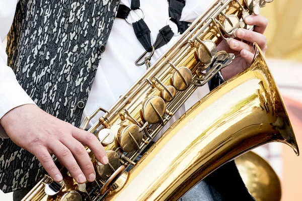 Man playing on saxophones. Musical instrument saxophone closeup.