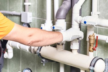 Bir işçi ya da mühendis bir apartman binası iletişimde mühendislik ile bir odada Isıtma sisteminin çalışması denetler.
