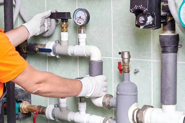 Bir işçi ya da mühendis bir apartman binası iletişimde mühendislik ile bir odada Isıtma sisteminin çalışması denetler.