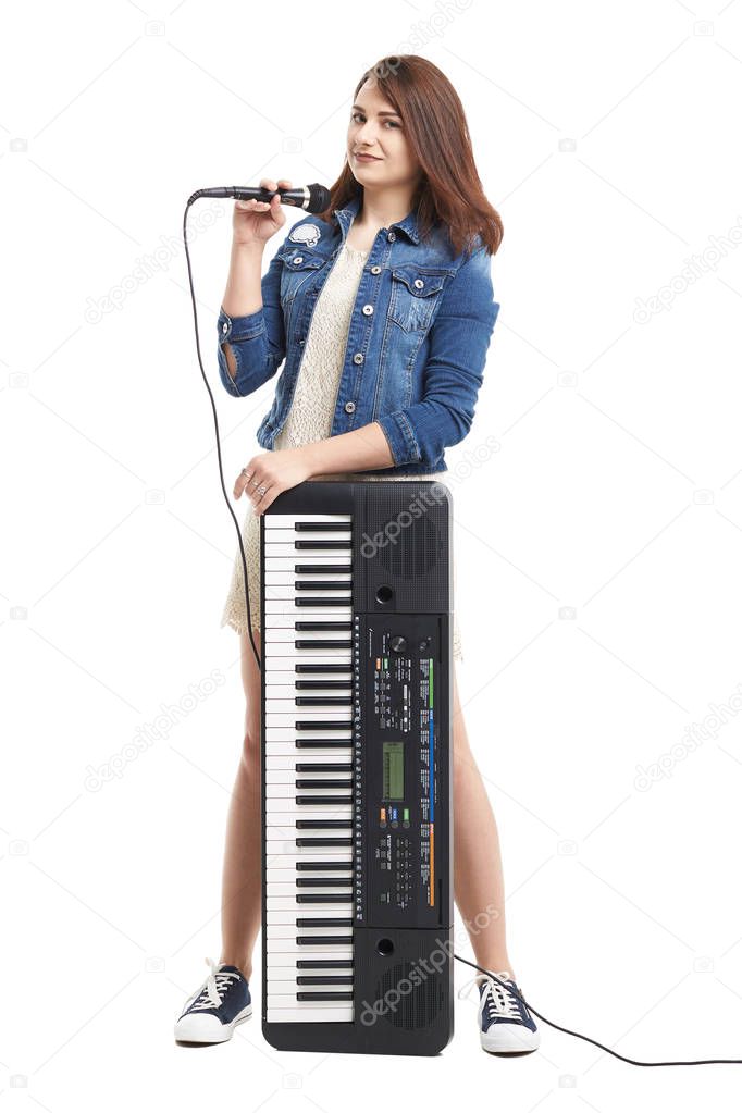 Young singer with microphone and synthesizer, electronic piano, isolated on white background.