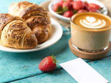 Kahvaltı ile closeup Fransızca kruvasan ve taze çilek ve cappuccino kahve.