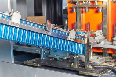 Bir closeup plastik şişe imalatı. Plastik şişe üretim teknolojik hattı. Konveyör otomatiktir.