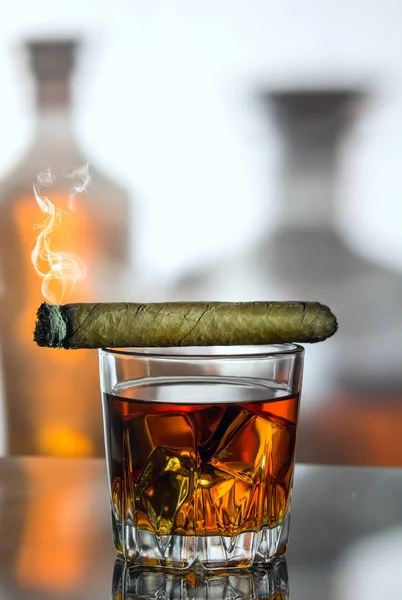 bir bardak viski ile buz iki şişe arka planı