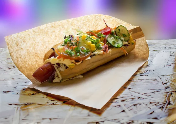 Street food, hot hotdog packed in a paper bag