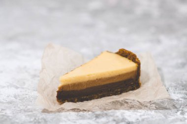 Üç çikolatalı cheesecake lezzeti. Arkaplanda pasta dilimi.