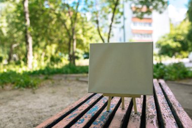 Yeşil yapraklar üzerinde beyaz boş maket şablonu poster resmi