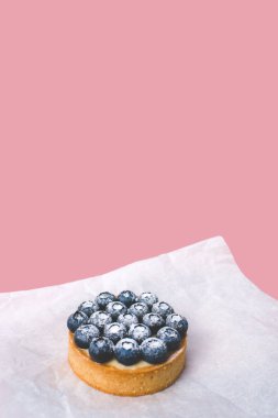 Limon kremalı ve karamelli kum sepeti. Taze yaban mersini ve pudra şekeriyle süslenmiş..