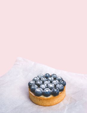 Limon kremalı ve karamelli kum sepeti. Taze yaban mersini ve pudra şekeriyle süslenmiş..