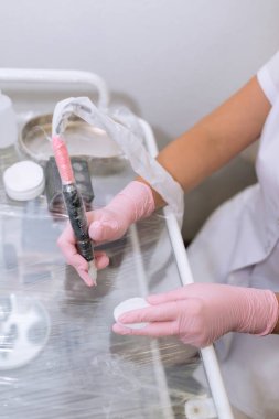 Pembe lateks tıbbi eldiven verin. Kalıcı makyaj için aletler. Efendinin ofisinde çalışmak için hazırlık.