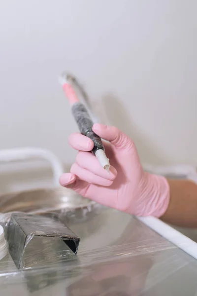 ピンクのラテックスの医療用手袋で手 永久的な化粧のためのツール 師匠の事務所での仕事の準備 — ストック写真