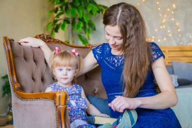 Evdeki komik küçük kız ve annesinin portresi. Aile, çocukluk ve eğlence kavramı