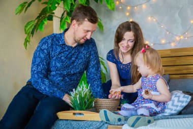 Mutlu genç ebeveynler ve küçük kızları birlikte oynuyorlar.