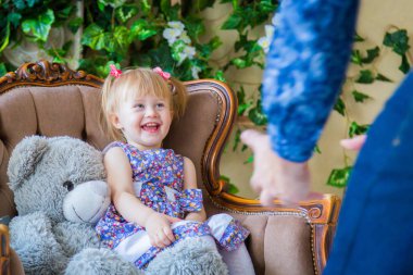 Mutlu genç ebeveynler ve küçük kızları birlikte oynuyorlar.