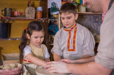 Potter çömlek atölyesinde seramik ile nasıl çalışılacağını gösteriyor.