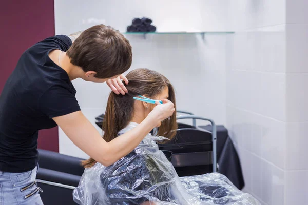 Cabeleireiro profissional fazendo penteado para o cliente — Fotografia de Stock